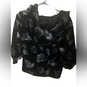 A black coat with some white leafs.